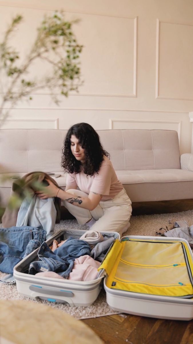 Packing two suitcases on a living-room floor